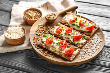 Tasty crispbreads with tomato, cheese and sprouts on table