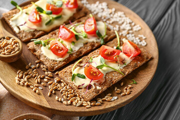 Tasty crispbreads with tomato, cheese and sprouts on plate