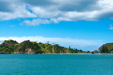 Beautiful seascape, Bay of Islands near Paihia, New Zealand, Cliffs, rocks and mountains in clear turquoise water of the sea and clouds in the sky