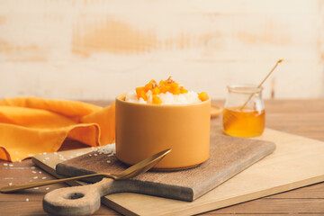 Bowl with boiled rice and pumpkin on table