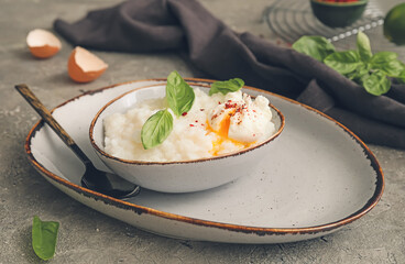 Bowl with boiled rice and egg on grey background