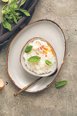 Bowl with boiled rice and egg on grey background