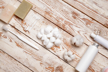 Cotton balls and cosmetics on wooden background