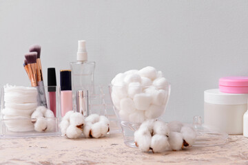 Fototapeta na wymiar Cotton balls with cosmetics on table in bathroom