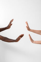 Hands of Caucasian woman and African-American man on light background. Racism concept