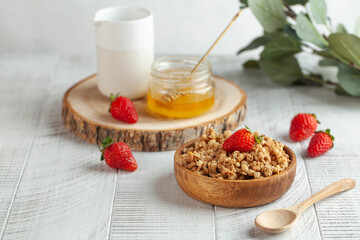 Homemade granola in a wooden bowl with strawberries and honey. The concept of a healthy Breakfast. Copy space.