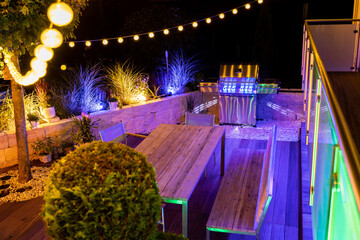 Gas barbecue on a stylish illuminated wooden terrace