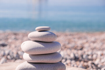 Symbol Scales is made of stones of various shapes. Balance of stones. Balancing stones on the shore. Tourism, travel.