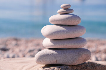 Symbol Scales is made of stones of various shapes. Balance of stones. Balancing stones on the shore. Tourism, travel.