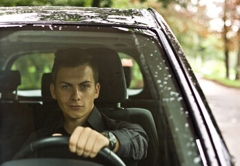 Front view. Portrait of a handsome man driving his car.