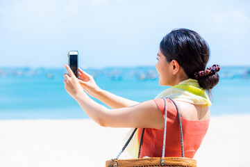 海の写真を撮る女性