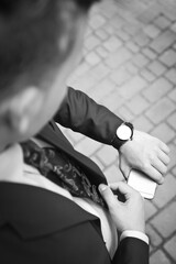 Fashion portrait of young businessman handsome model man in casual cloth suit with accessories on hands, steel watches,grey jeans and bracelets.