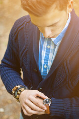 Fashion portrait of young businessman handsome model man in casual cloth suit with accessories on hands, steel watches,grey jeans and bracelets.
