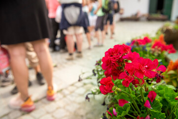 Naklejka premium Group of people standing in line in a hot summer, waiting for the arrival of the train, the bus, the cable car.