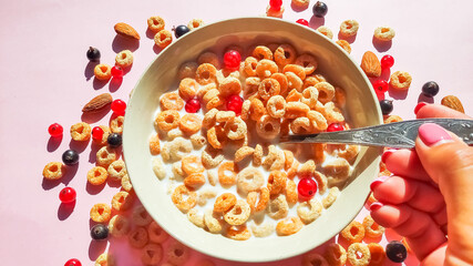 bowl of breakfast rings with milk and berries isolated on white background, top view.Delicious corn rings with berries on table.Healthy breakfast ,cereal rings in bowl with milk, honey, berries
