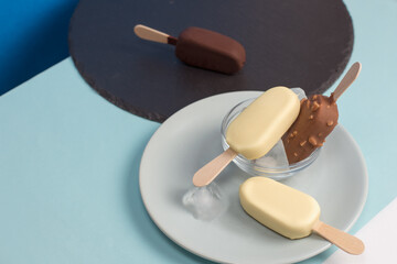 Ice cream with vanilla icing and chocolate on wooden sticks