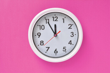 White clock on a pink background 