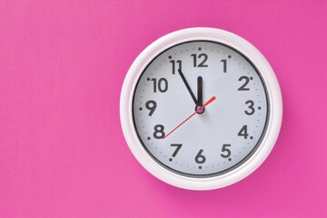 White clock on a pink background 