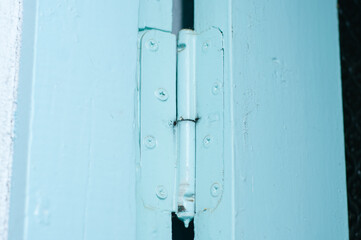 Door hinge of an old blue wooden door