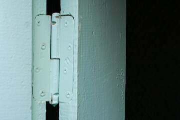 Door hinge of an old blue wooden door