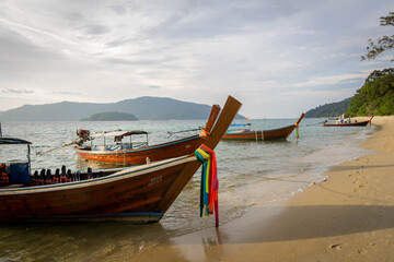 Koh Lipe / Thailand | August 03 2016: Long tail boats stopped in a paradise beach at Koh Lipe, Thailand
