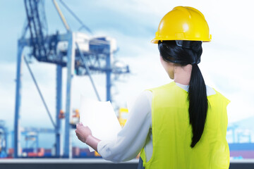 Rear view of an Asian construction worker with hardhat holding planning paper