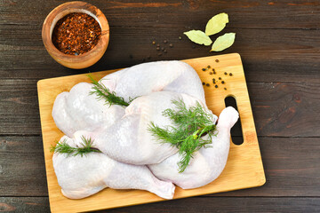 Chicken legs with spices on a wooden background. Food concept. Top view, place for text.