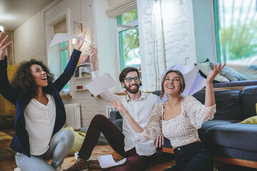Fototapeta premium Happy boyfriend and two girlfriends rejoicing in overall success
