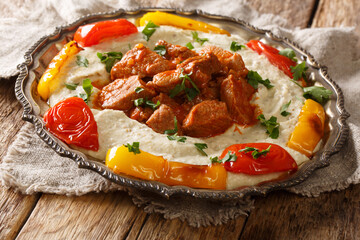 Turkish Kebab Ali Nazik Recipe cooked lamb in red sauce with mashed eggplant closeup in the plate. Horizontal