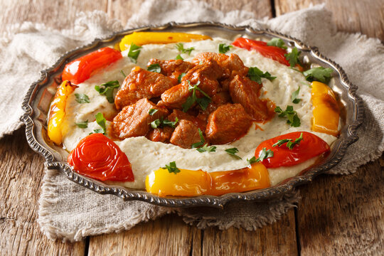Turkish lamb AliNazik kebab in red sauce with aubergine puree closeup in the plate. Horizontal