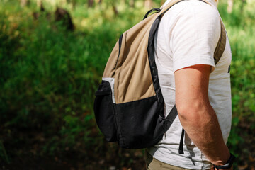 Banner for sports entertainment in the forest, tourism in the forest, backpack on a man against the background of forest greenery, tourist active lifestyle