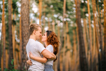 A couple in love has wonderful moments of happiness and joy in the pine forest. Love and tenderness.Lifestyle concept and place for text, copyspace