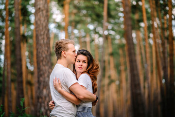 A couple in love has wonderful moments of happiness and joy in the pine forest. Love and tenderness.Lifestyle concept and place for text, copyspace