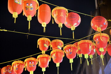 Vor dunklem Nachthimmel aneinandergereihte Papierlaternen in Chinatown