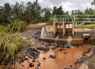 Spillway for minihydropwer station. A small dam guides water toward a minihydropower station in...