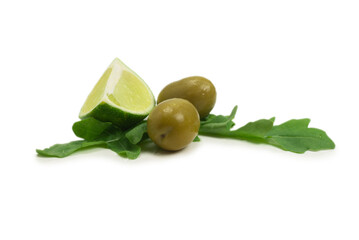 Two olives, piece of lemon and leaves of arugula isolated on white