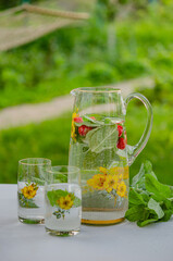 In the summer garden of a country house. Have a nice summer weekend, relax. Soft drink (lemonade) with mint and mint leaves, a healthy product