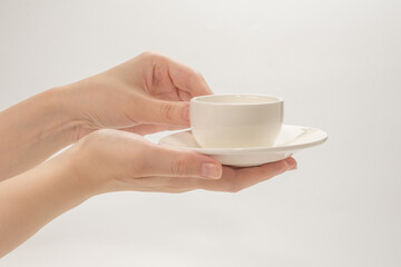 Empty coffee cup in woman hand isolated on white.