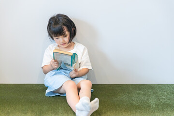 小さい女の子が本を一人で読んでいる　girl 虐待　kids