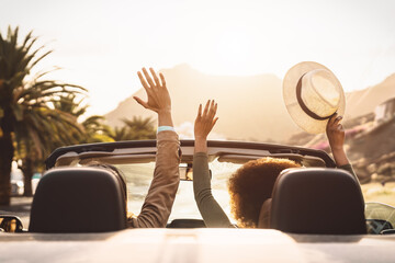 Happy young couple doing road trip in tropical city - Travel people having fun driving in trendy...