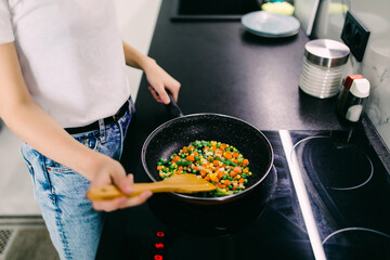 Joyful beautiful woman is on the kitchen prepares to eat
