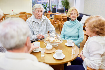Gruppe Senioren im Altersheim beim Kaffee trinken und reden im Gemeinschaftsraum