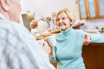 Senioren machen Smalltalk bei einer Tasse Kaffee im Aufenthaltsraum im Altersheim
