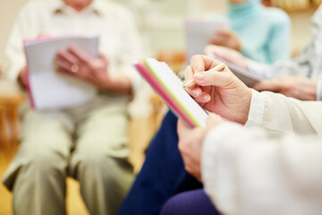 Senioren füllen Fragebogen aus oder schreiben Erinnerungen auf in der Schreibtherapie