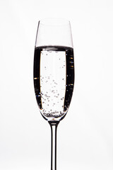 Transparent alcoholic drink with bubbles in a champagne glas cup. Isolated on white background.