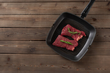 raw beef steaks in a pan