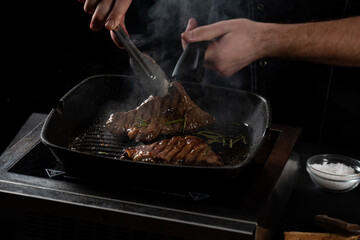 the chef prepares a beef steak in a pan