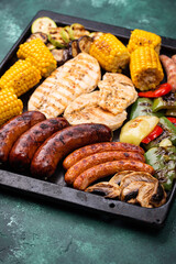 Grilled sausages, meat, and vegetables.