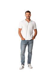 Fototapeta premium cheerful man in white t-shirt smiling while standing with hands in pockets on white