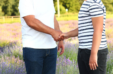 Fototapeta na wymiar Dad and son teenager in nature shake hands. Strong male handshake. Father and son. The concept of friendship in the family. Family values